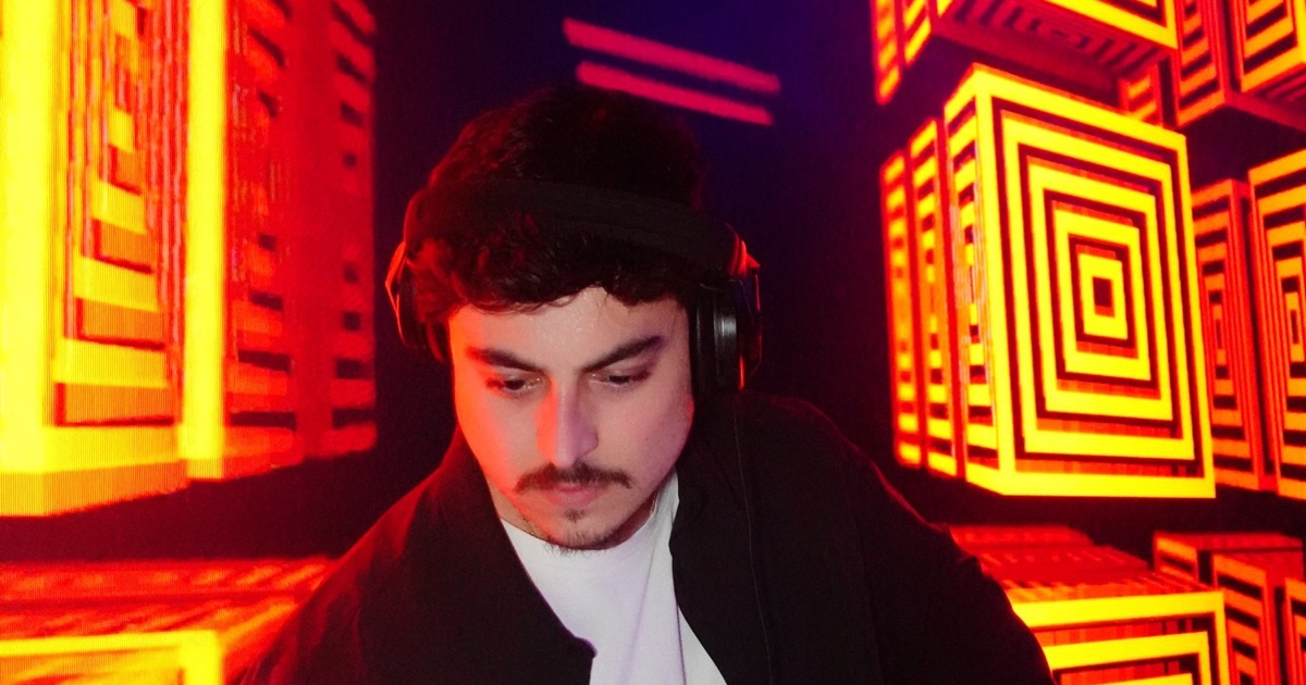 DJ OTEO performing under red LED light